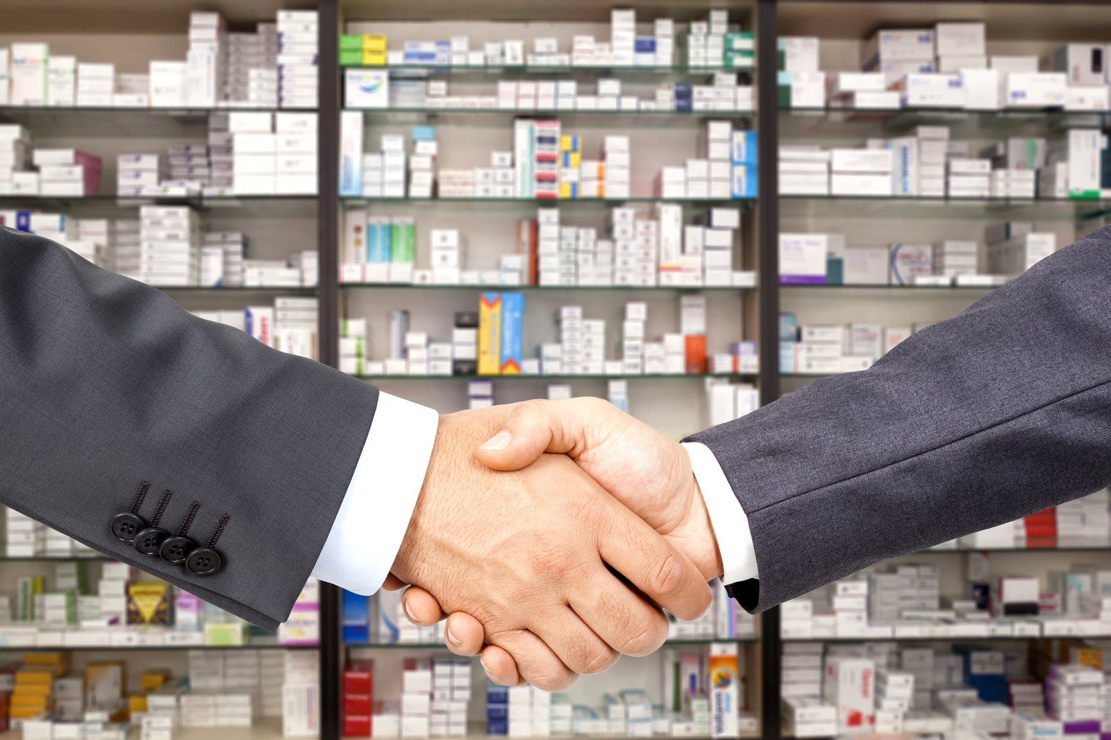 Handshake in front of pharmacy shelves